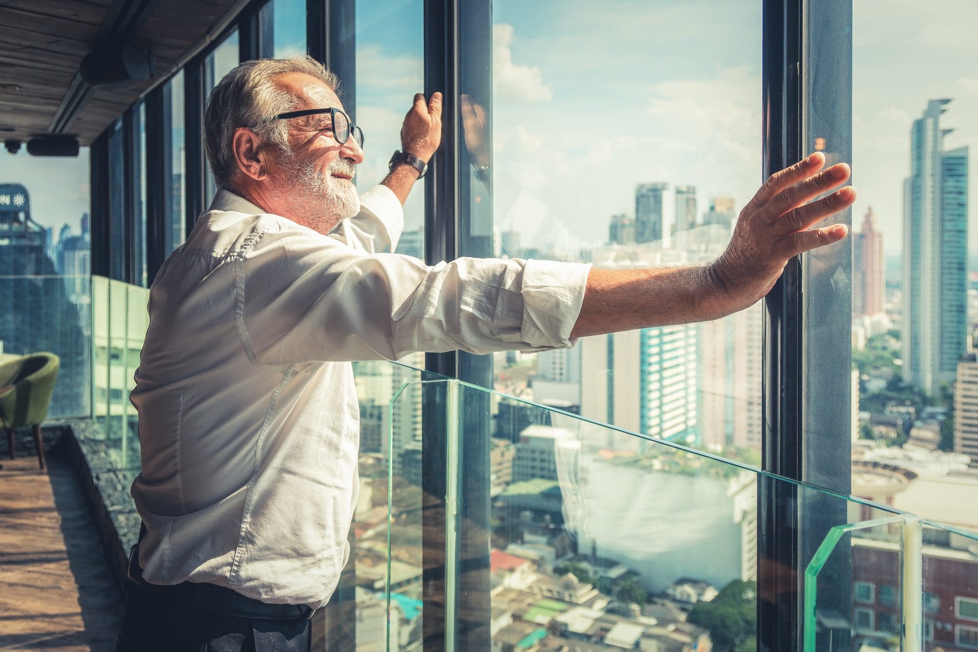 portrait of senior businessman with beard and glasses feeling confident standing in executive room in business building