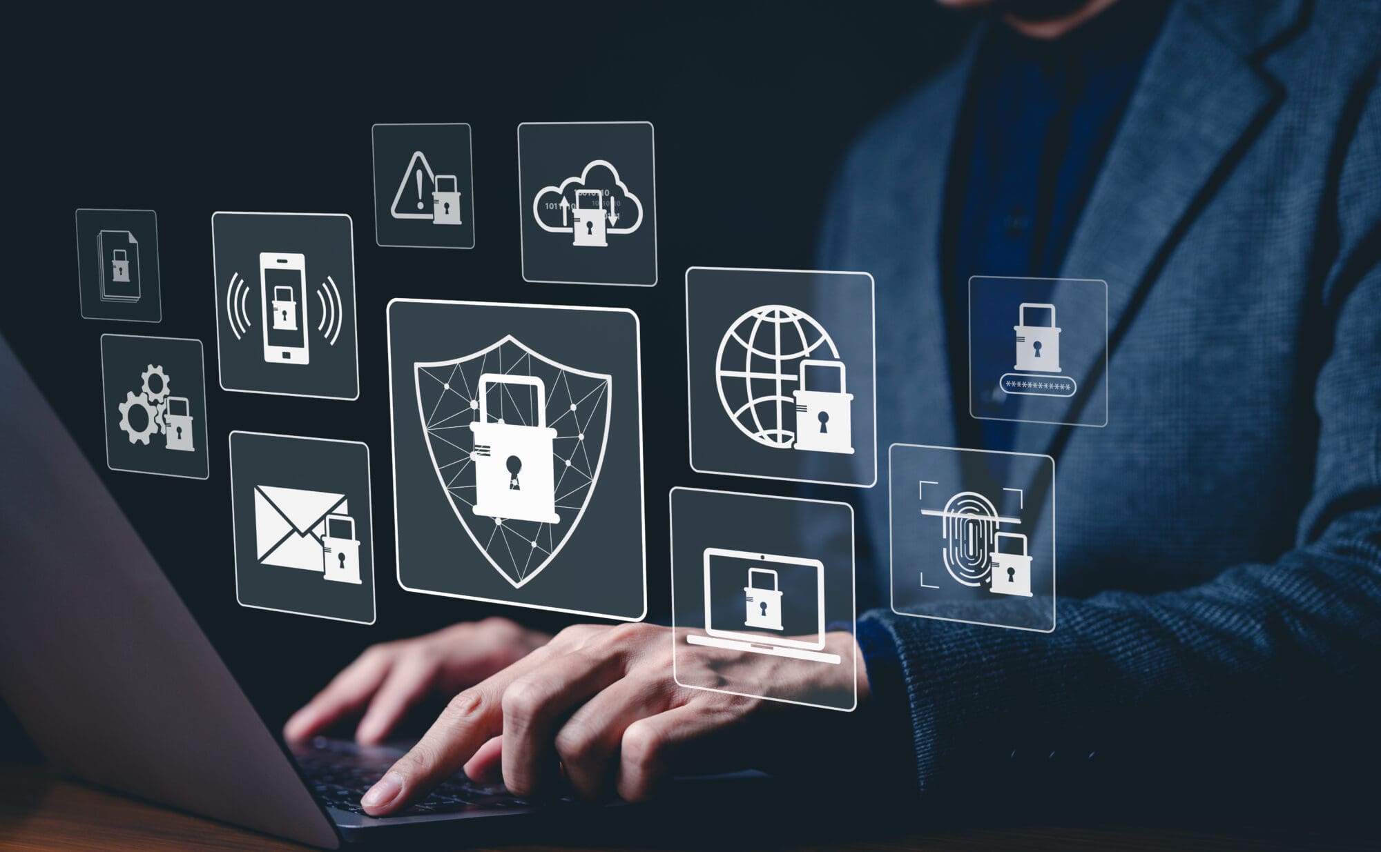ransomware A person wearing a suit, typing on a laptop, with icons of secure programs hovering over the laptop.